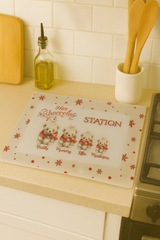 Kitchen counter with a placemat featuring teddy bears and text on a white tiled wall background.