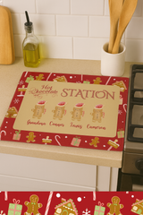 Christmas-themed hot chocolate station mat on a kitchen counter with gingerbread men and presents design.