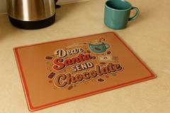 Brown placemat with 'Dear Santa, Send Chocolate' text on a beige surface with a teal mug and silver kettle.