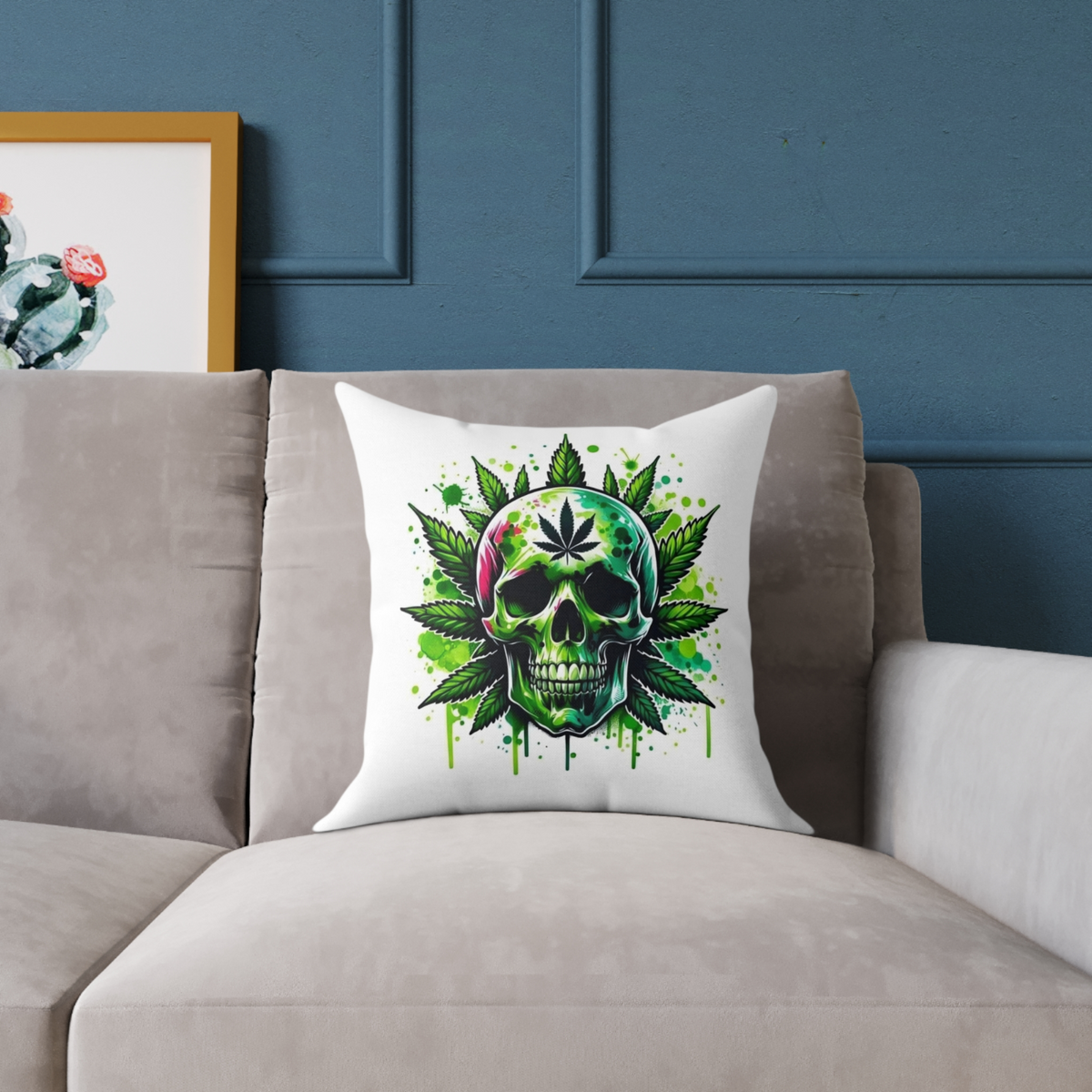 “White throw pillow on grey couch featuring green skull and cannabis leaves design”
