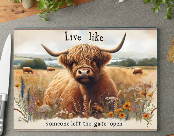 Plaque with a highland cow illustration and text 'Live like someone left the gate open' on a wooden surface.