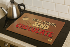 Brown placemat with 'Dear Santa, Send Chocolate' text on a kitchen counter.