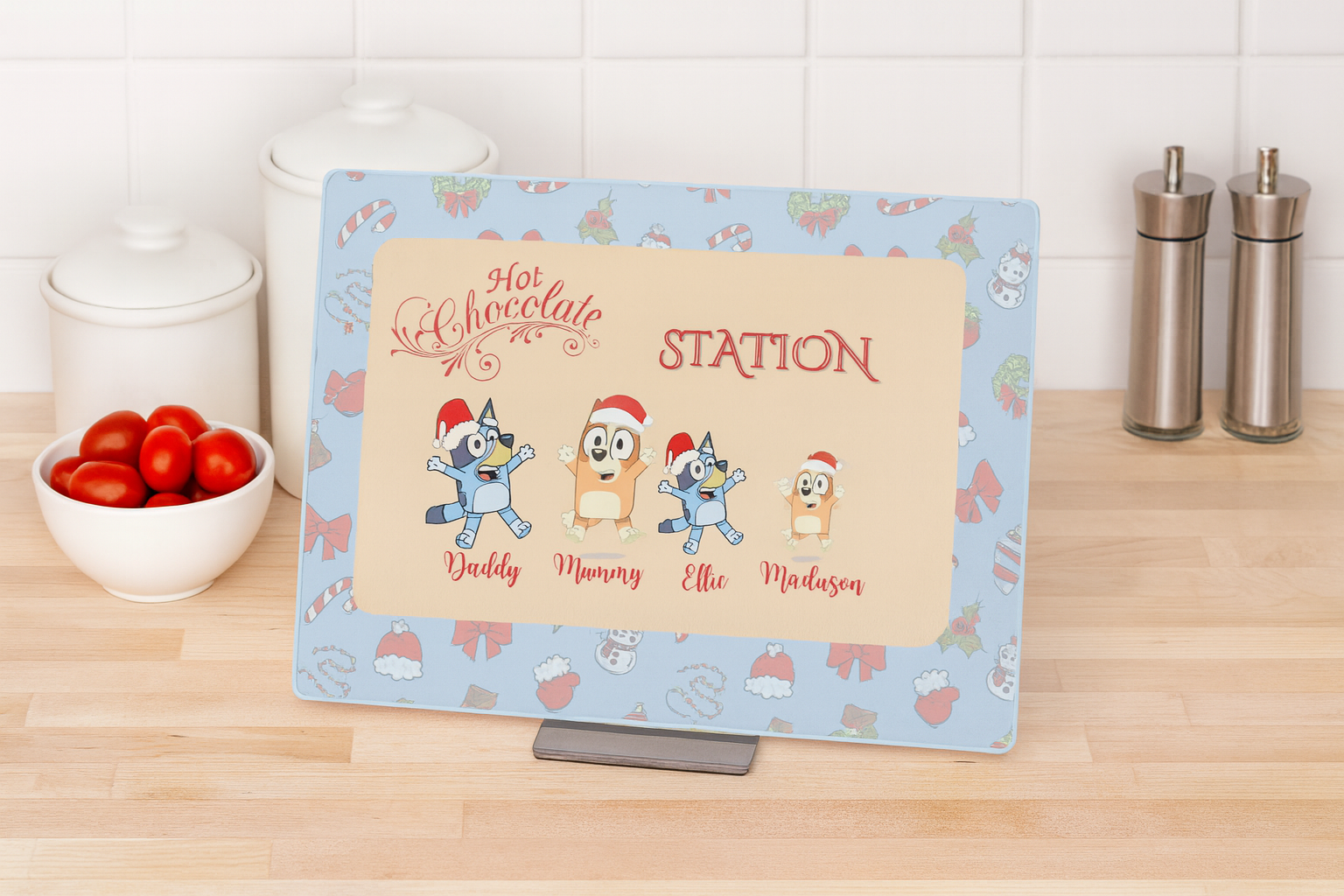 Personalized hot chocolate station sign with cartoon characters on a kitchen counter.