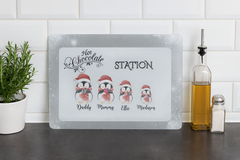 Hot chocolate station sign with penguin illustrations on a kitchen counter.