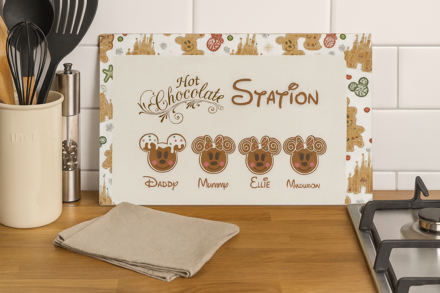 Kitchen setting with a 'Hot Chocolate Station' mat featuring cartoon faces and utensils.